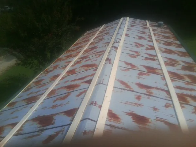 Rusted metal roof panels with new wood purlins before replacement — Storm Damage Roof Repair in Culver by Roofing Brothers