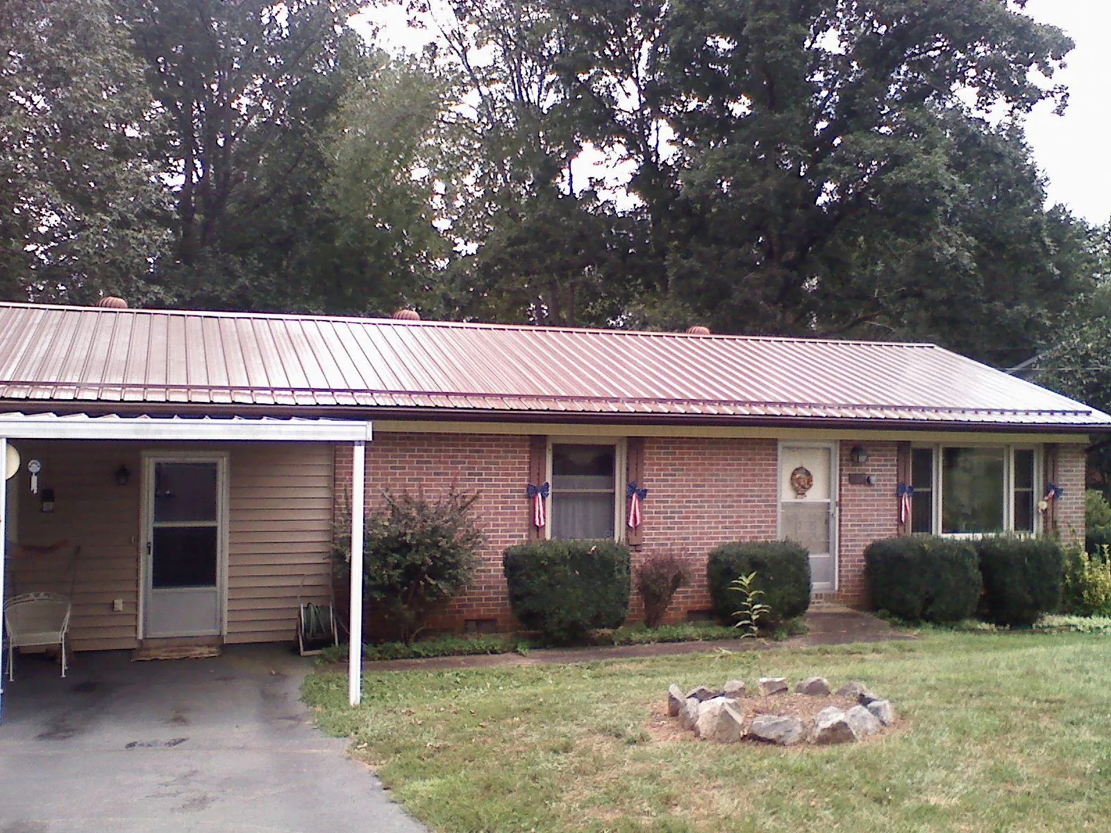 Bronze metal roof and carport on a brick ranch home — Roof Repair work by our crew in Culver